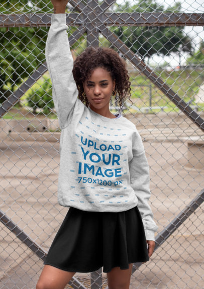 Heathered Sweatshirt Mockup of a Woman Posing Against a Wire Fence 28642