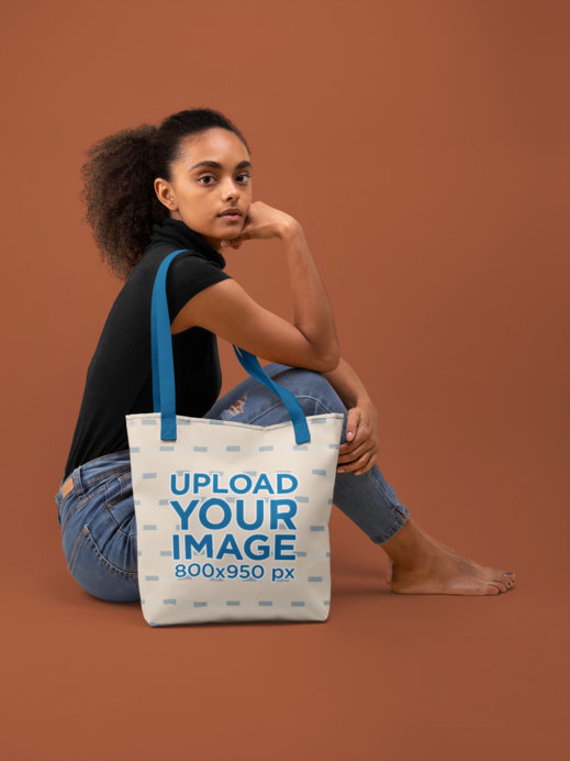 Customizable Strap Tote Bag Mockup of a Woman Sitting on the Floor of a Studio 