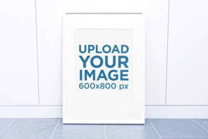 Mockup of a Poster Frame Leaning Against a White Wall