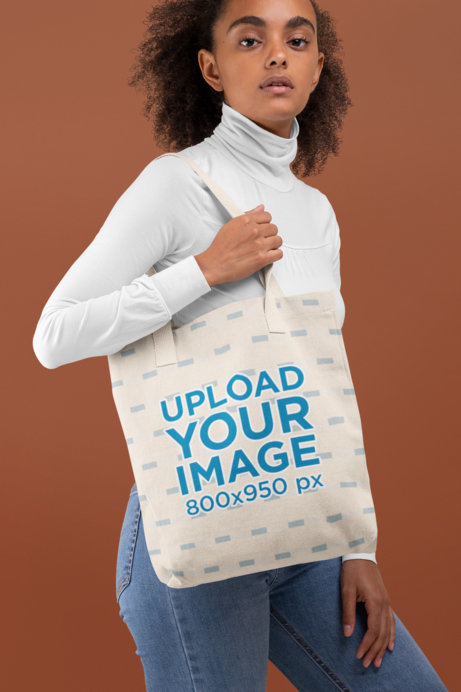 Tote Bag Mockup of a Woman With Curly Hair Against a Plain Backdrop 