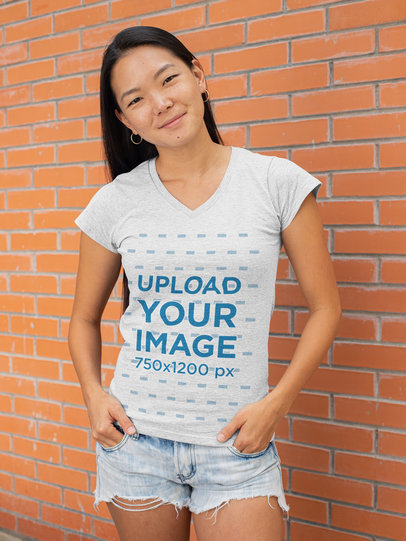 V-Neck Heather T-Shirt Mockup of a Young Woman Posing Against a Brick Wall