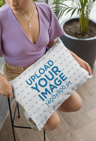 Mockup of a Young Woman Sitting with a Pillow on Her Lap