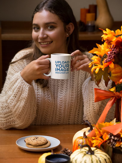 Mockup of a Woman Holding an 11 oz Coffee Mug at a Dinner Table