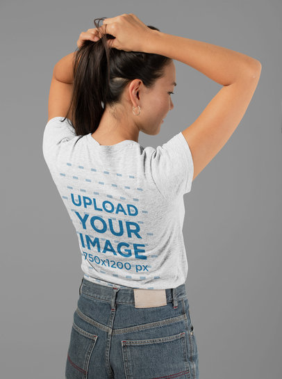 Mockup of the Back of a Heather T-Shirt Featuring a Woman Holding Her Hair 
