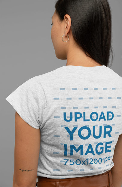 Mockup of a Woman Wearing a Heather T-Shirt and Facing the Studio Wall