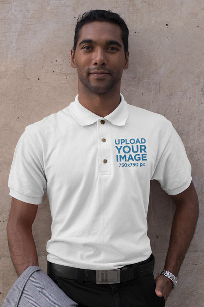Mockup of a Man Wearing an Embroidered Polo Shirt Against a Concrete Wall