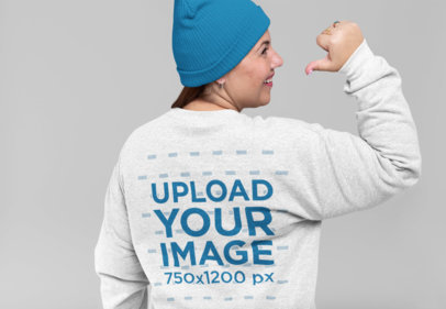 Mockup of a Woman Pointing at the Back of Her Crewneck Sweatshirt 