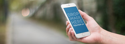 Mockup Template of a Woman at a Park Using an iPhone