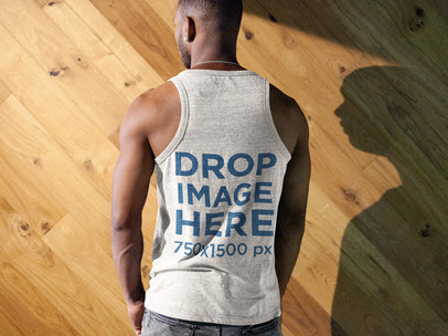 Back Shot of a Black Man Wearing a Tank Top Mockup Facing a Wooden Wall a9363b