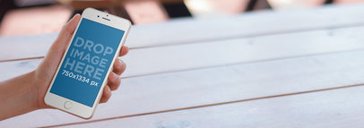 iPhone Mockup Featuring a Guy Sitting at a Picnic Table a10092