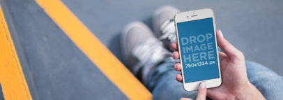 Mockup Template of a Woman Sitting on a Staircase Using an iPhone