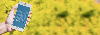 Mockup Template of a Woman Using an iPhone in a Garden