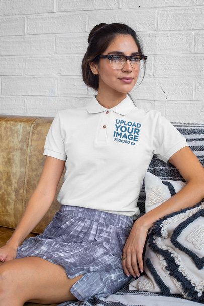 Embroidered Polo Shirt Mockup Featuring a Woman with Glasses Sitting on a Sofa
