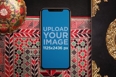 Mockup of an iPhone X in Portrait Position Featuring a Colorful Cloth 671-el
