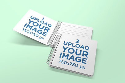 Mockup Featuring an Opened and a Closed Spiral Notebook Against a Solid Color Backdrop 