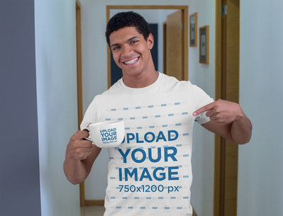 Mockup of a Young Man with a T-Shirt Pointing at a 24 oz Mug 29253