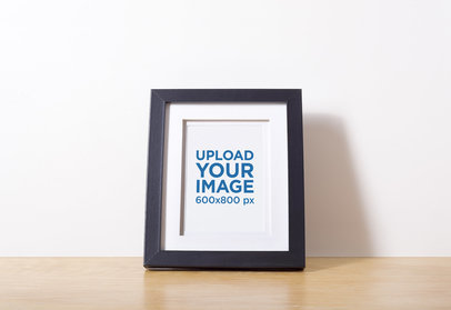 Mockup of a Photo Frame Leaning on a Plain Wall