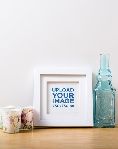 Photo Frame Mockup Featuring Some Candles and a Glass Bottle