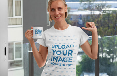 Mockup of a Woman with an 11 oz Coffee Mug Pointing at Her T-Shirt 