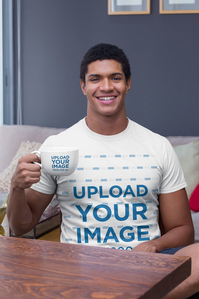 T-Shirt Mockup of a Smiling Man in the Livingroom Holding a 24 oz Coffee Mug 29254