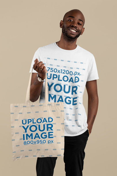 T-Shirt Mockup of a Man Holding a Tote Bag in a Studio