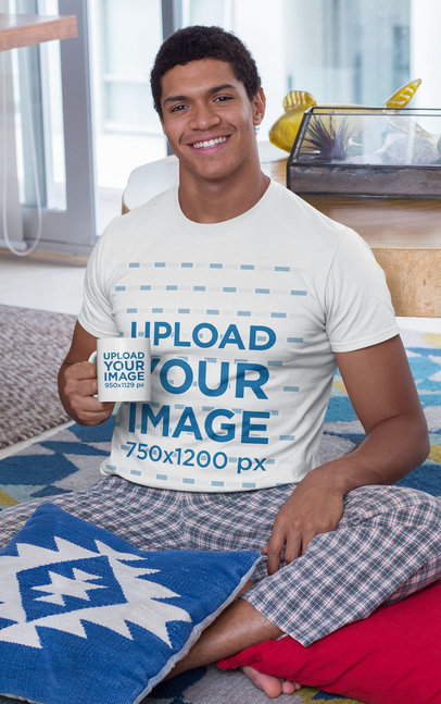T-Shirt Mockup of a Man Holding an 11 oz Coffee Mug While Sitting on the Floor