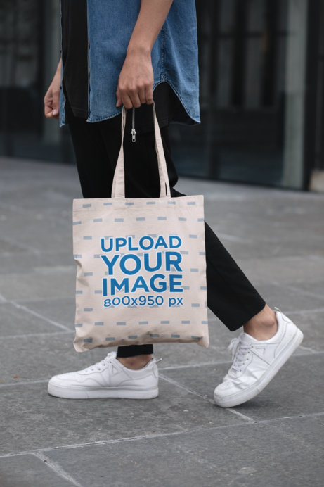Cropped Face Mockup of a Man Holding a Tote Bag in the Street