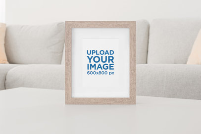 Art Print Mockup Featuring a Wooden Picture Frame at a Living Room Table