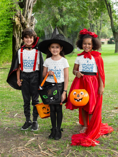 T-Shirt Mockup of Three Kids with Halloween Costumes in the Park 