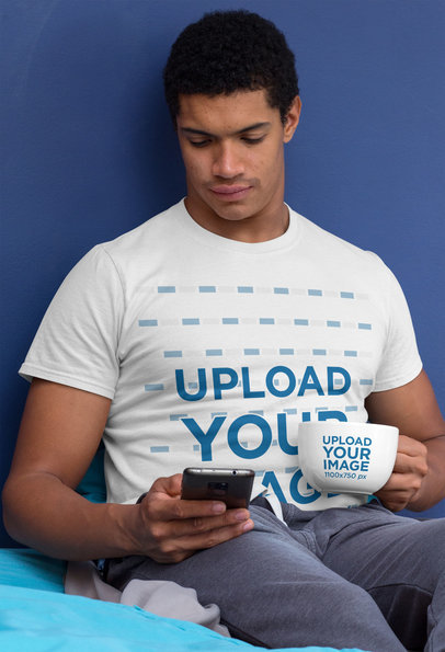 T-Shirt Mockup of a Man Holding a 24 oz Mug While Checking His Phone 29256