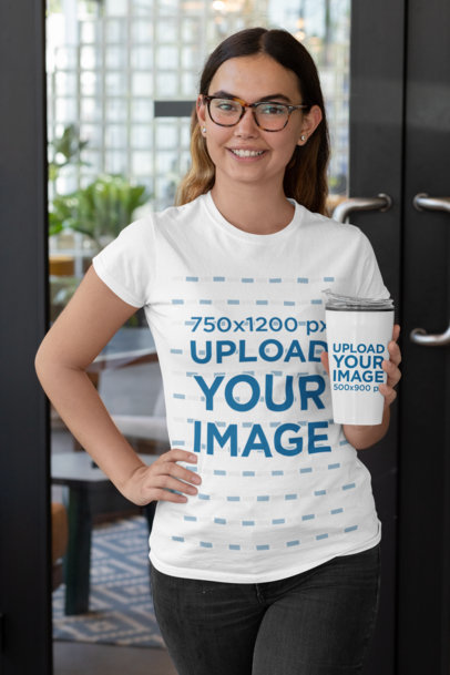 T-Shirt Mockup of a Woman Holding a Travel Mug Outside a Restaurant 