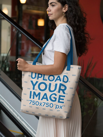 Mockup of a Woman Holding a Tote Bag with Customizable Strap at a Mall