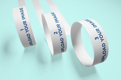 Mockup of Three Paper Wristbands Rolling Towards the Camera 635-el