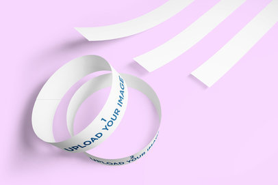 Mockup of Multiple Paper Wristbands Lying on a Solid Color Surface