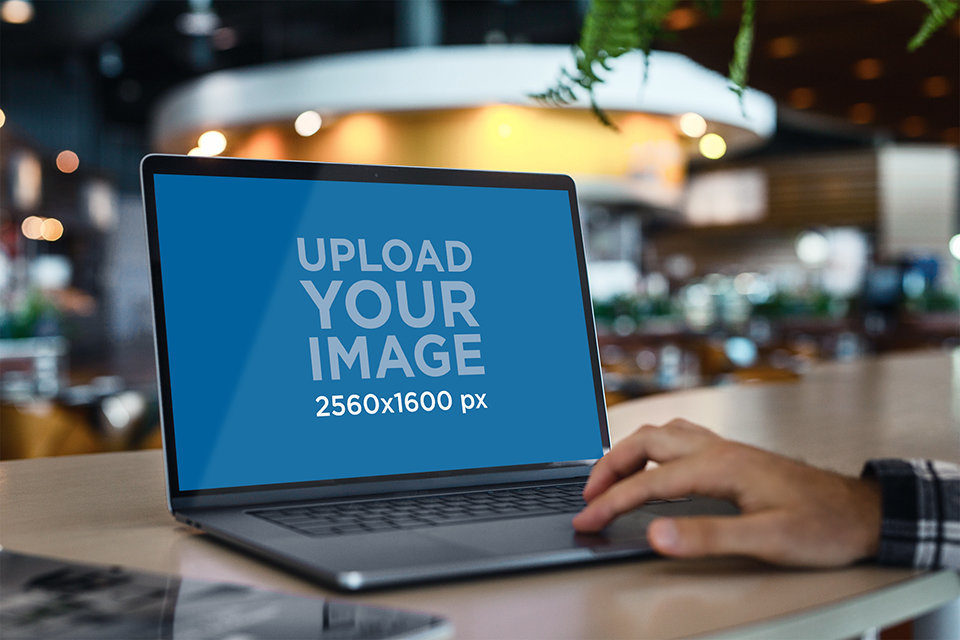 Mockup of a MacBook Pro Being Used in a Public Space