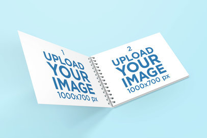  Mockup Featuring an Opened Spiral Notebook Against a Plain Backdrop 