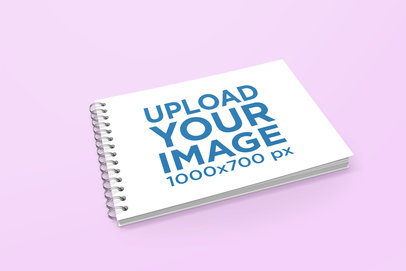Mockup of a Closed Spiral Notebook Lying on a Solid Color Surface 