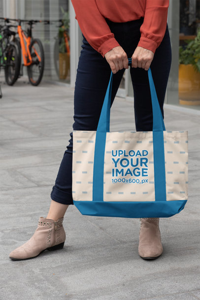 Mockup of a Woman Holding a Weekend Bag with Customizable Strap in the Street 