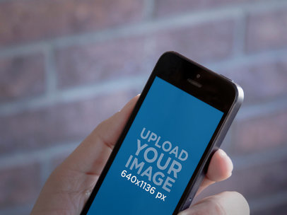 Mockup of an iPhone 5 Featuring a Brick Wall in the Background 