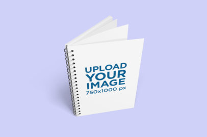 Mockup Featuring a Spiral Notebook Standing on a Solid Color Surface 