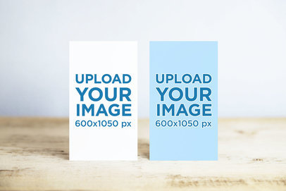 Mockup of Two Vertical Business Cards on a Wooden Surface