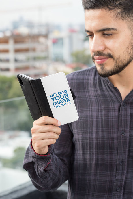 Wallet Case Mockup of a Man Looking at His iPhone 11