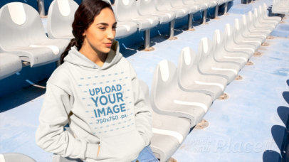 Hoodie Video of a Young Woman Sitting on a Stadium Bleachers 
