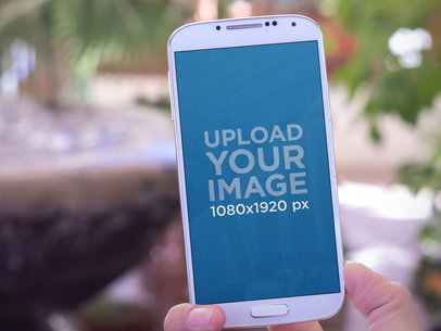 Mockup of a Hand Holding a Samsung Galaxy S4 in Portrait Position