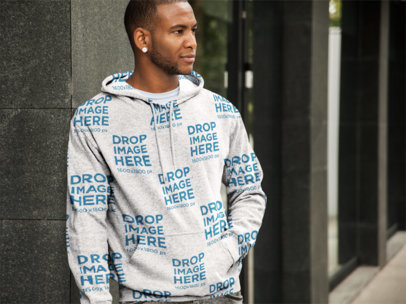 Mockup Template of a Man in a Hoodie Leaning Against a Wall