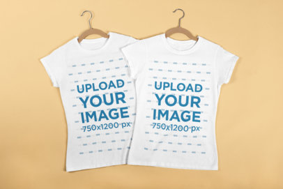 Mockup of Best Friends T-Shirts with Hangers Laying Flat on a Surface