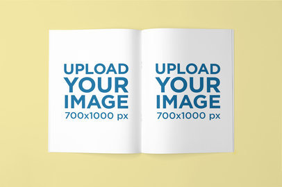 Mockup Featuring an Open Magazine Lying Against a Plain Backdrop 
