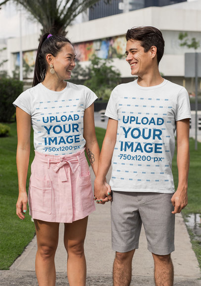 Mockup of a Young Couple With Customizable T-Shirts Holding Hands