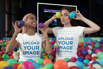 Mockup of Two Friends with Matching Crewneck T-Shirts Playing at a Ball Pit 
