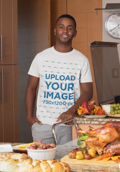 Mockup of a Smiling Man Wearing a Customizable T-Shirt During a Thanksgiving Dinner